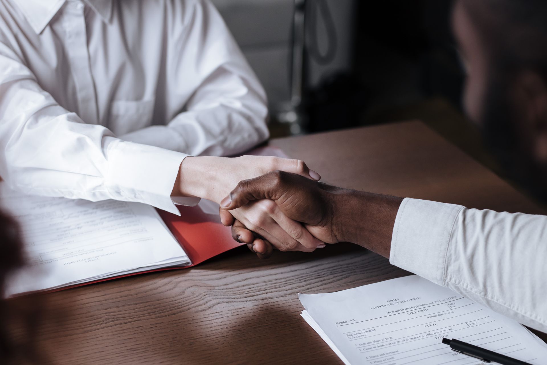 Apretón de manos sobre documentos legales en una consulta